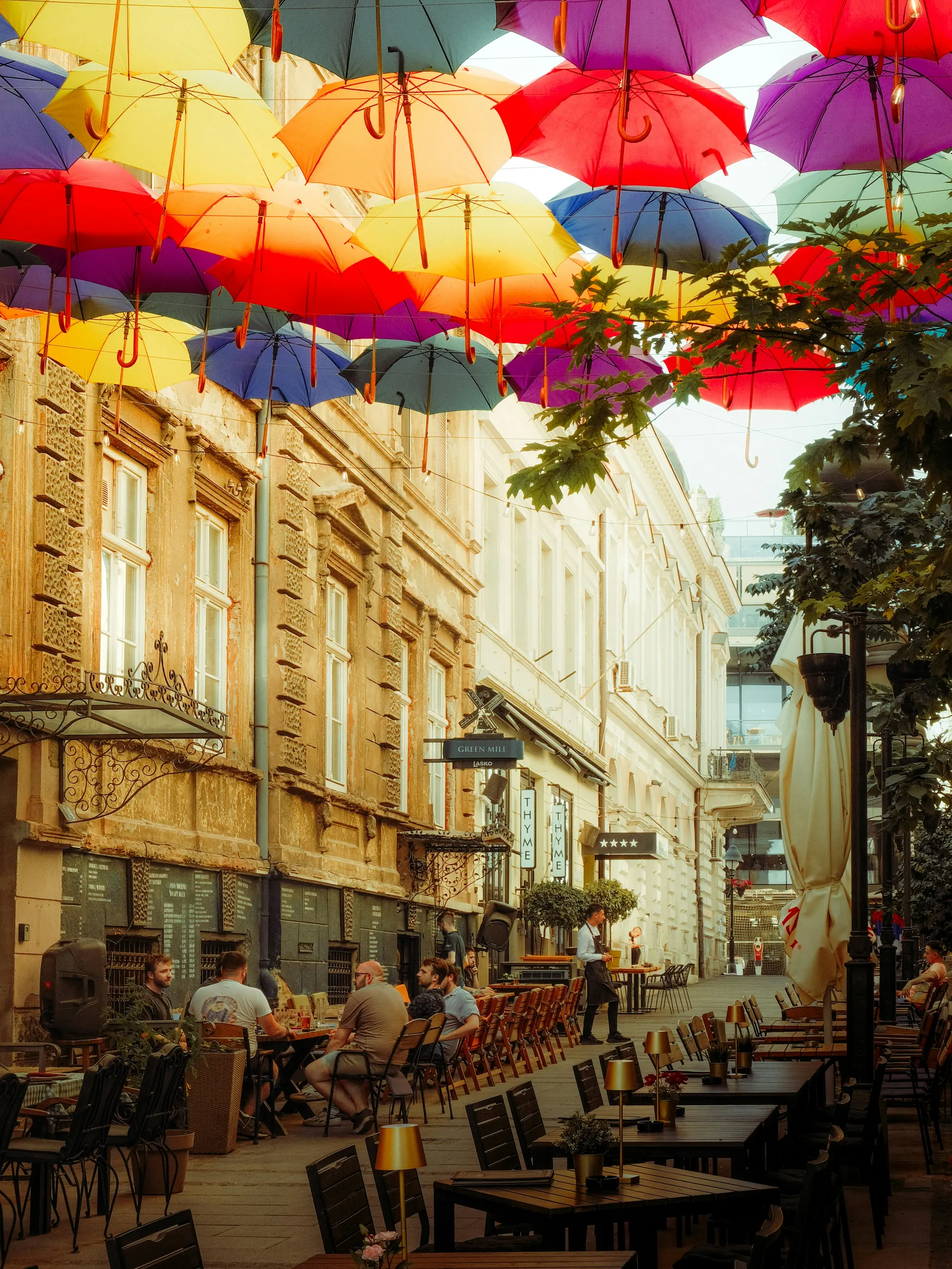 A lively street of local restaurants beneath colorful umbrellas